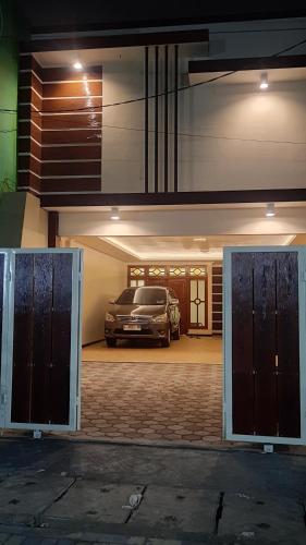 a car parked inside of a garage with a car parked at Guest House Omah Ningrat Surabaya in Surabaya
