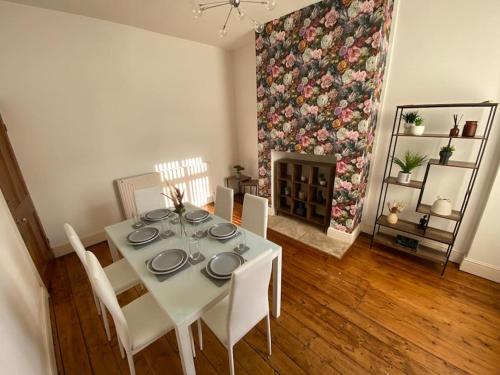 a dining room with a table and chairs and a fireplace at 7 bed - Spacious House - Central Manchester in Manchester