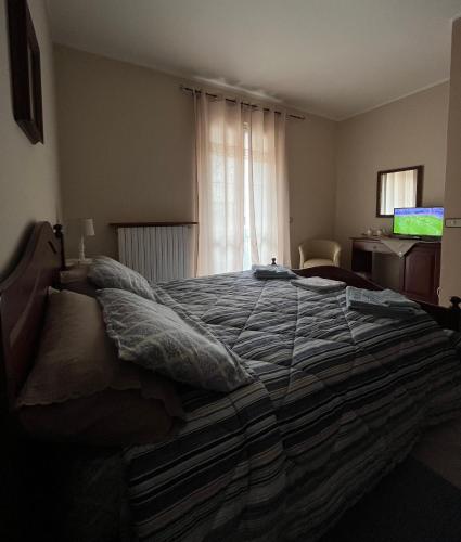 a bedroom with a large bed with pillows on it at Locanda 130 in Fonni