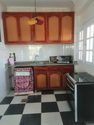 a kitchen with wooden cabinets and a checkered floor at Rezeiky Hotel & Camp in Luxor