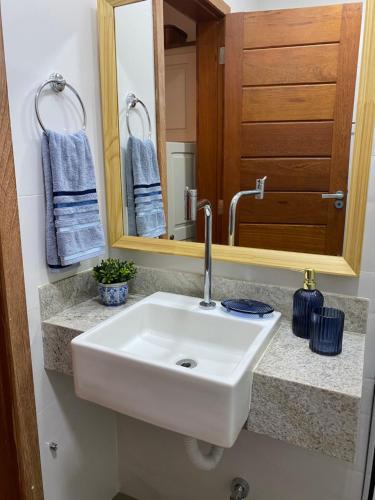 a bathroom with a white sink and a mirror at Apartamento na Vila de Barra Grande - Bahia in Barra Grande