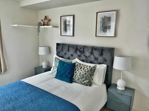 um quarto com uma cama azul e branca com almofadas em Luxury Northampton Town Centre Apartment em Northampton