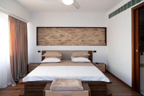 a bedroom with a bed and a brick wall at Apartament CENTRAL 1 in Drobeta-Turnu Severin