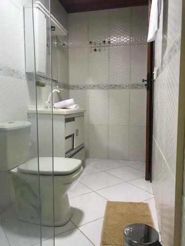 uma casa de banho com um WC e uma cabina de duche em vidro. em BLUE DOOR BRASIL em Abraão