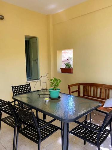 a dining room table with chairs and a potted plant on it at Διαμέρισμα σε ανακαινισμένο αρχοντικό 19ου αιώνα, κέντρο Μύρινας in Mirina