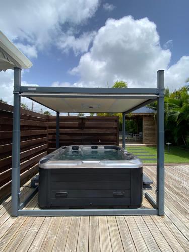 a hot tub on the deck of a house at VILLA ALOEREVE in Sainte-Anne