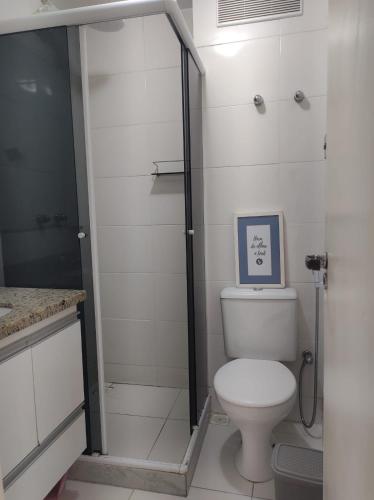a white bathroom with a toilet and a shower at Ribeira Guest House in Angra dos Reis