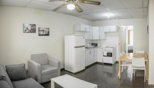ein Wohnzimmer mit einem Sofa und einem Tisch sowie eine Küche in der Unterkunft Cardedeu Suites in San Salvador