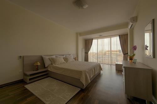a bedroom with a bed and a large window at Samali Residence in Eforie Nord