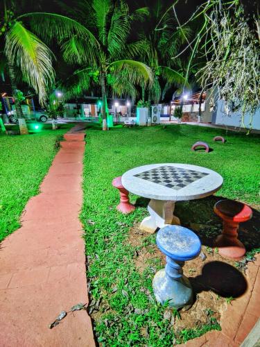 a table and stools in a park at night at POUSADA POR DO SOL in Olímpia