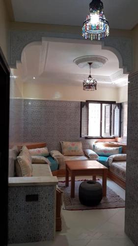 a living room with a couch and a table at Appartement RDC in El Jadida