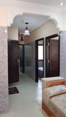 Zimmer mit einem Schlafzimmer mit einem Bett und einem Flur in der Unterkunft Appartement RDC in El Jadida