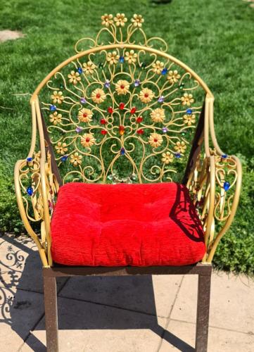 a red cushion sitting on top of a chair at Refugio madera estilo árabe con estatuas, estanques y un pequeño zoo in Albacete