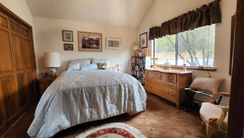 a bedroom with a bed and a dresser and a window at Yosemite Mountain Retreat in Oakhurst