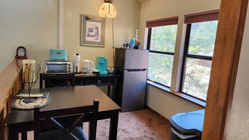 una cucina con frigorifero, tavolo e finestra di Yosemite Mountain Retreat a Oakhurst