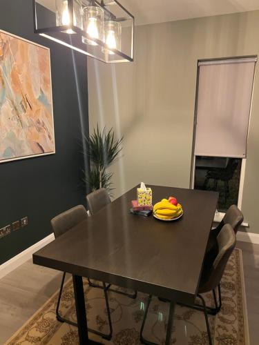 a black dining room table with a plate of bananas on it at 3 bed rooms Vip family house in Dublin