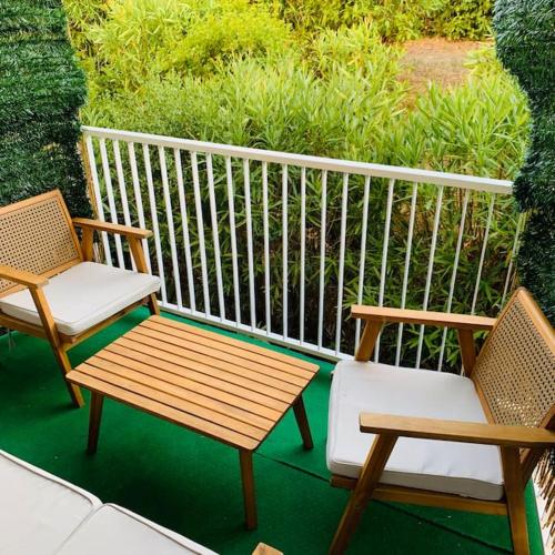 - deux chaises et un banc en bois sur une terrasse couverte dans l'établissement Appartement entier vue dégagée avec parking, à Montpellier