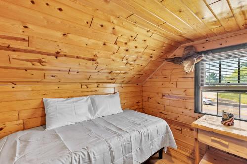 a bedroom with a bed in a wooden cabin at Eagles Nest Motel Unit 3BD in Escanaba