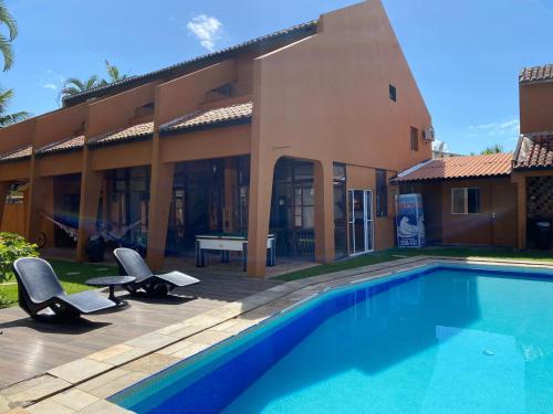 een huis met een zwembad voor een huis bij Pousada Ponta dos Corais in Guarujá