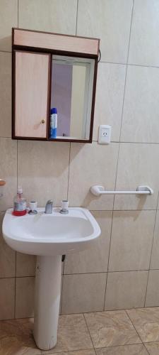 uma casa de banho com um lavatório branco e um espelho. em Kenny G em Tinogasta