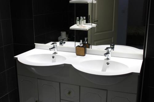 a bathroom with two sinks and a large mirror at Villa Rubis - proche aéroport in Matoury