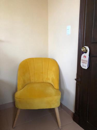 una silla amarilla sentada en una esquina al lado de una puerta en Villas Segovia Hotel Boutique & Suites en Cozumel