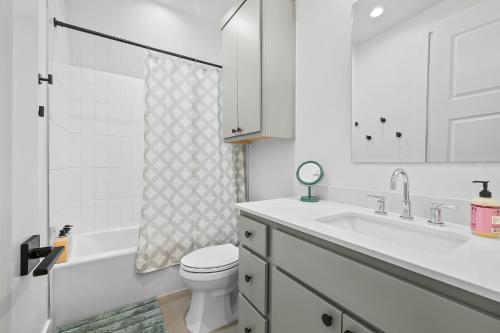 a white bathroom with a sink and a toilet at Gruene Lake Haus - Modern A-Frame with Fire Pit in New Braunfels