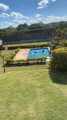 a pool in a yard with two people in it at Toca da Leoa in São Roque