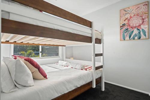 a bedroom with two bunk beds and a window at The Seachange - Brand New, Beachy Family Retreat. in Ettalong Beach