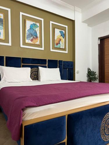 ein Schlafzimmer mit einem großen Bett mit einer lila Tagesdecke in der Unterkunft Balcony View/Aesthetic One bedroom Apartment in Islamabad