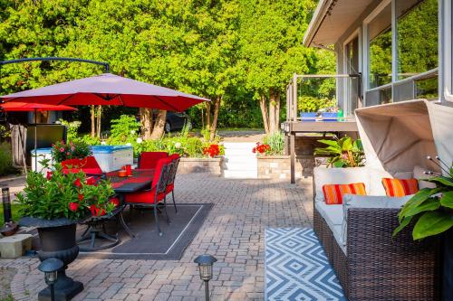 a patio with a table and chairs and an umbrella at Nature Oasis Mar Suite in Dundas