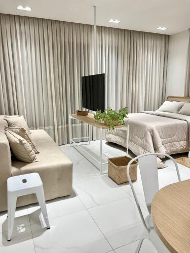 a living room with two beds and a tv at Loft Boho - Cosmopolitan - Oktoberfest in Blumenau