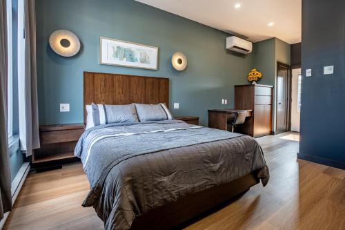 - une chambre avec un grand lit aux murs bleus dans l'établissement Lux Hotel, 