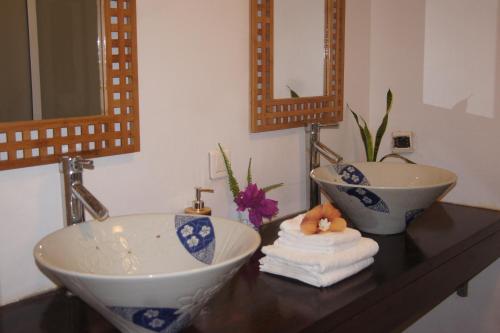 a bathroom with two sinks and towels on a counter at Vanylle Lodge in Punaauia