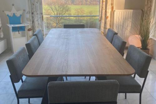 een houten tafel en stoelen in een kamer bij Charming Ardennes house with jacuzzi for 8 people in Noiseux