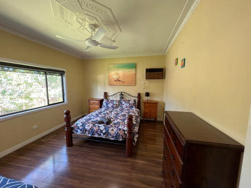 una camera con letto, cassettiera e finestra di Wombat Cottage Albury ad Albury