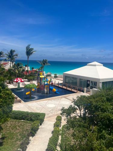 a building with a playground next to the ocean at Hermoso Depto con vista al mar en zona hotelera. in Cancún