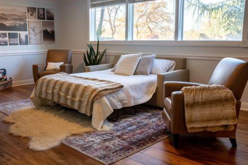 a bedroom with a bed and a chair and a window at Cottonwood Heights - Lower Level of Mountain Home! in Cottonwood Heights