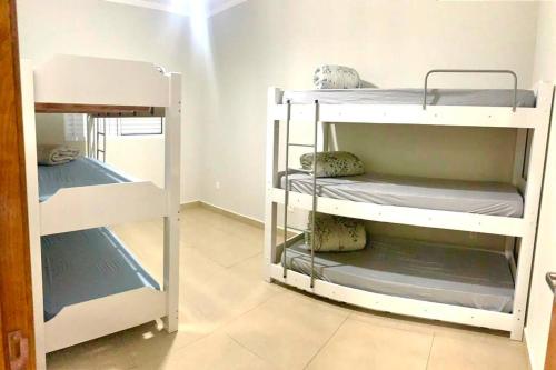 a room with three bunk beds in a room at Recanto Algodão-Doce - Área de Lazer em São Carlos in São Carlos