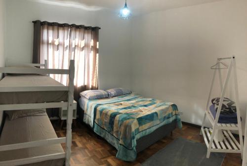 une petite chambre avec un lit et une fenêtre dans l'établissement Apto central, com vista deslumbrante!, à Curitiba