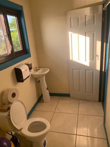 uma casa de banho com um WC e um lavatório em Paradise Divers Hotel em Útila