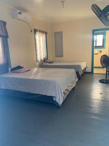 um quarto com 2 camas e uma janela em Paradise Divers Hotel em Útila