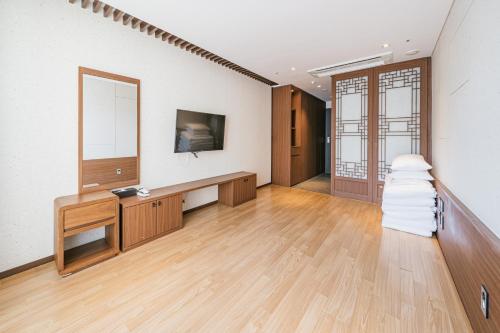 a large room with a mirror and a wooden floor at Hotel Air City Jeju in Jeju