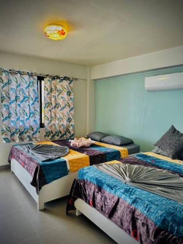 a bedroom with two beds and a window at Playa Blanca Beach Resort in Puerto Galera