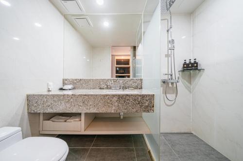 uma casa de banho com um lavatório, um WC e um chuveiro em Hotel Air City Jeju em Jeju