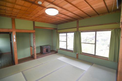 an empty room with green walls and windows at Yamaganorizou - Vacation STAY 02773v in Yamaga