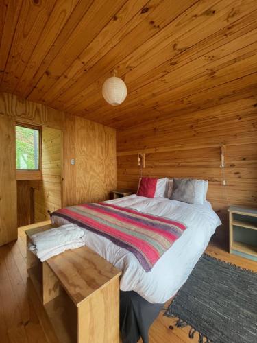 a bedroom with a bed in a wooden cabin at La Ritoqueña Hotel de Playa in Concón