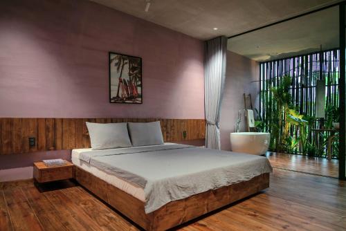 sypialnia z łóżkiem i dużym oknem w obiekcie AnNam Village w mieście Vung Tau