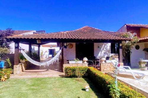 une maison avec un hamac dans la cour dans l'établissement Casa da Lua, à São Pedro da Aldeia