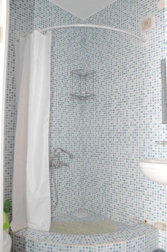a bathroom with a shower with a white shower curtain at Guest House Fairy Tale in Kaji-Say
